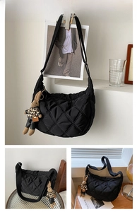 Close-up of black quilted nylon dumpling bag featuring a cute rabbit charm accessory