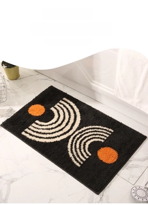 Detail of a plush anti-slip bathroom mat with orange dots on a dark grey background