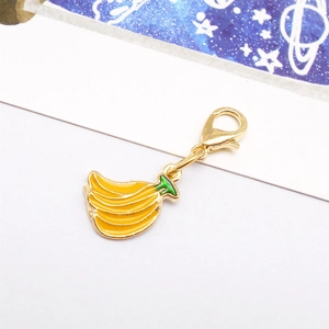 Detailed close-up of a golden banana charm with yellow enamel finish and spring clip