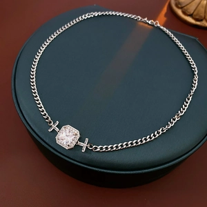 Détail d'un collier en argent avec pendentif carré en zircone présenté sur un socle rond