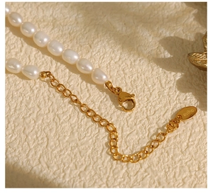 Macro view of freshwater pearls with a gold lobster clasp and engraved logo charm