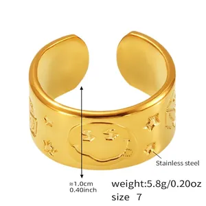 Detailed close-up of wide gold stainless steel ring with smiley and star relief