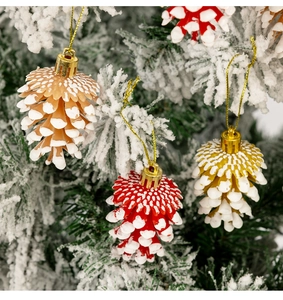 Gros plan d'ornements de Noël en forme de pomme de pin avec effet neige sur des branches