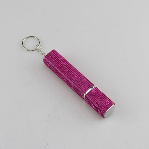 Detailed close-up of rose red rhinestone encrusted perfume bottle keychain with metal ring