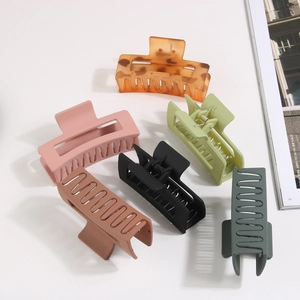 Set of six matte rectangular hair claw clips in various neutral colors on a white surface