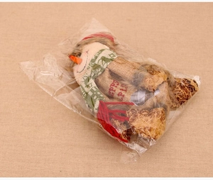 Detail of Christmas snowman gift bag in brown burlap with Merry scarf inside polybag