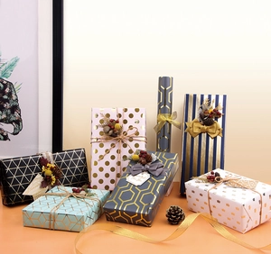 Dettaglio di scatole regalo dorate geometriche con nastri eleganti e decori