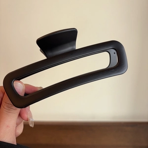 Macro shot of large black matte acetate hair claw clip with rectangular cutout design