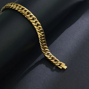 Dettaglio macro di bracciale a catena cubana in acciaio inossidabile dorato con chiusura