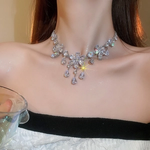 Close-up of a silver flower necklace with sparkling zircon droplets on a model