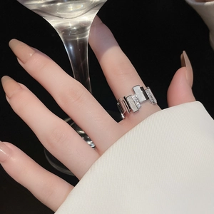 Detailed view of silver irregular geometric ring with white shell inlay and zircons