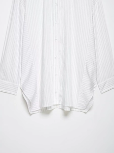 Detail of loose fit long sleeve striped shirt with vertical and side stripe patterns