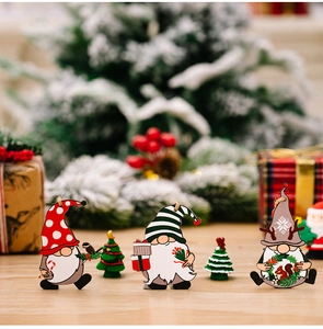 Close-up of three wooden Christmas gnome ornaments with polka dots and snowflake patterns
