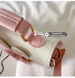 Detailed view of quilted cream and pink mini shoulder bag with decorative bow