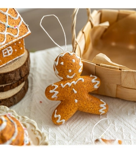 Close-up of a gingerbread man ornament with white icing details and a hanging loop