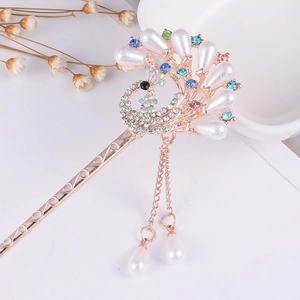 Detail of golden peacock hair pin with colorful rhinestones and pearl tassels