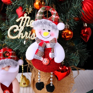 Detail of fabric snowman ornament with red scarf on a decorated Christmas tree branch