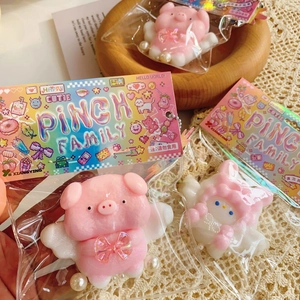 Close-up of a soft pink pig squishy toy with wings in individual brand packaging