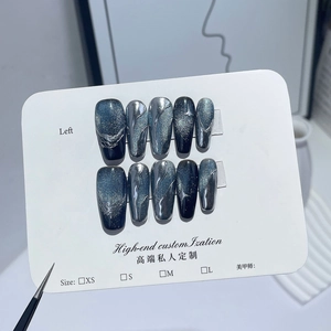 Faux ongles œil-de-chat bleu profond avec détails 3D argentés sur carte de tailles