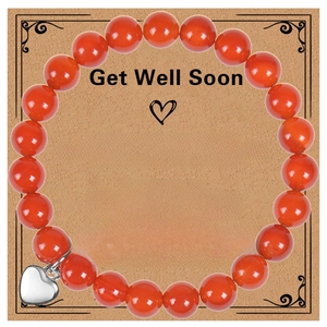 Macro detail of red natural stone bead bracelet with silver heart charm on gift card