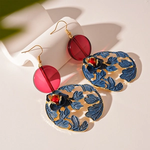 Detailed close-up of retro floral earrings with red resin and blue filigree leaf design
