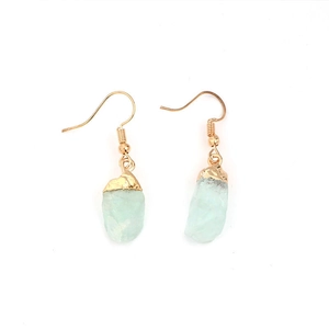 Detailed view of light green raw stone earrings with gold electroplated hooks and edges