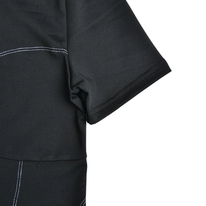 Detail view of black ribbed bodysuit featuring contrast white stitching on sleeve and shoulder