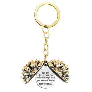 Detail of sunflower keychain featuring retro gold petals and engraved silver inner disk
