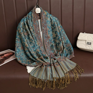 Detail of teal cashmere-feel scarf with gold paisley jacquard pattern and fringe