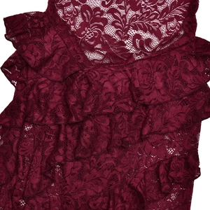 Close-up of wine red lace fabric with floral patterns and tiered ruffle details