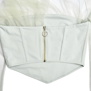 Dettaglio posteriore del top a fascia verde chiaro con tulle beige e cerniera dorata sul retro