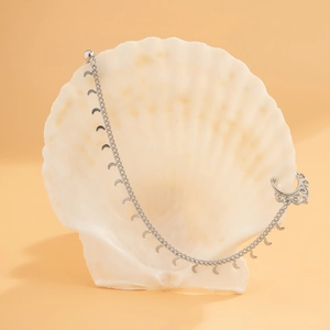 Ethnic star moon tassel silver nose ring with long chain on a white seashell