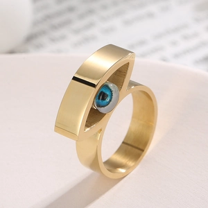 Makroaufnahme eines goldenen Edelstahlrings mit einem stilisierten blauen Evil Eye