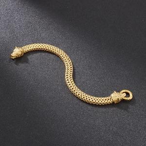 Detailed view of gold braided chain bracelet with double wolf head motifs in hip hop style