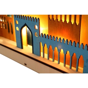 Detail of laser-cut wooden moon lamp with warm LED light and blue mosque architectural motif