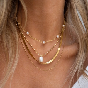 Layered 18K gold stainless steel necklaces featuring freshwater pearls and snake chains