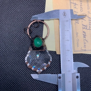 Macro detail showing 3.2cm width measurement of bronze maple leaf pendant with green agate