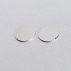 Gros plan de pendentifs circulaires en acier inoxydable poli pour bijoux DIY