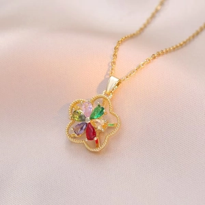Detailed close-up of a golden rotating flower pendant with multi-colored crystals on pink silk