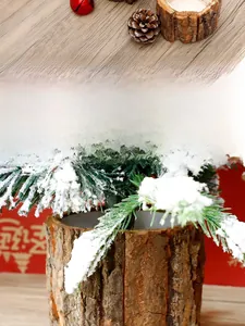 Detailed view of mini cedar tree with pine cones and red bells in a wood bark bucket