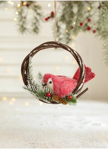 Close-up of a red wool felt bird in a brown wicker wreath with pine cones and berries