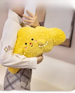 Close-up of soft plush croissant pillow with cute embroidered face held by person