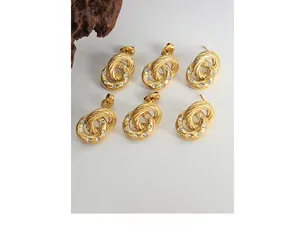 Detailed close-up of three pairs of 18K gold-plated double-hoop earrings with small crystals
