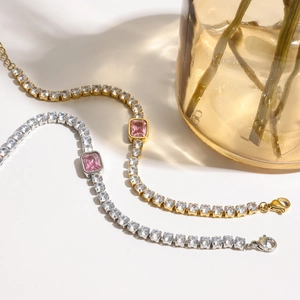 Detail of tennis bracelets with pink central stone and silver or gold plating
