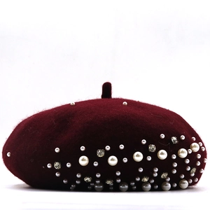 Detail of wine red wool beret with hand-sewn pearls and faceted rhinestones decor