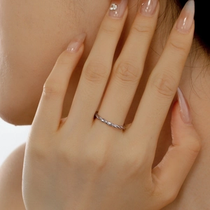 Close-up of a delicate S925 sterling silver rope twist ring on a female finger