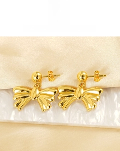 Detailed close-up of 18K gold-plated bow earrings with high-shine polished metallic finish