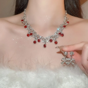 Close-up of elegant bow-knot jewelry set with red water-drop gemstones and sparkling crystals