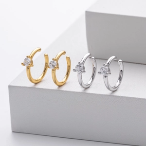 Macro view of C-shaped ear cuffs with cubic zirconia in gold and silver finish