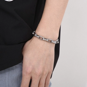 Close-up of minimalist silver titanium steel chain bracelet worn on a male wrist